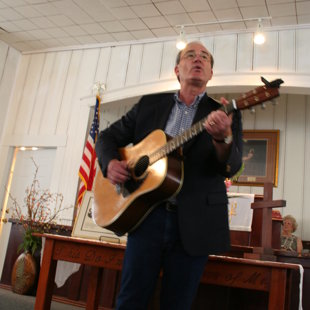 Rev. Vic Casad plays and sings to close the program